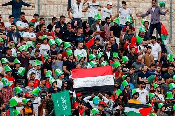 شعار و پرچم حمایت از یمن در بازی فوتبال عربستان با فلسطین