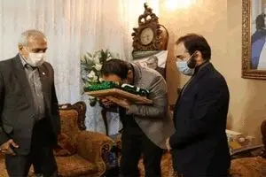 اهدای پرچم آستان قدس رضوی به خانواده شهید فخری‌زاده